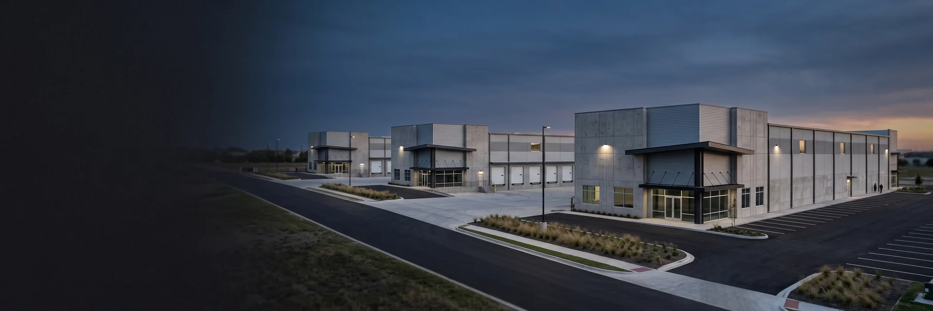 Row of identical new-construction retail and branch buildings in a suburban Texas development at dusk