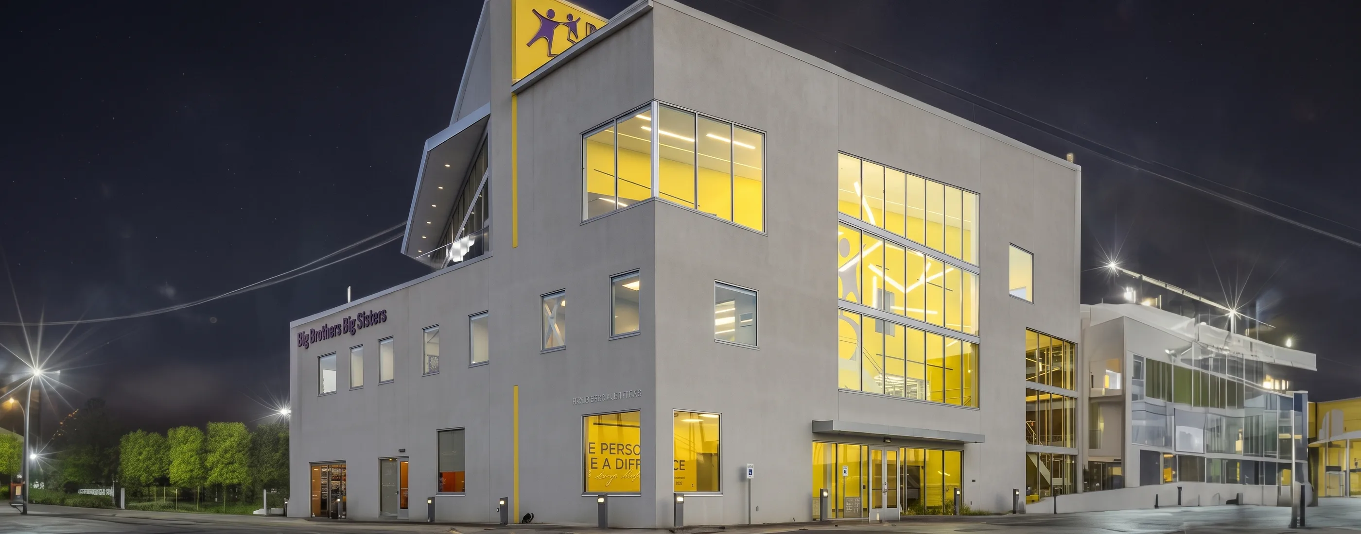 Big Brothers Big Sisters Houston headquarters exterior at night with lit yellow glazing