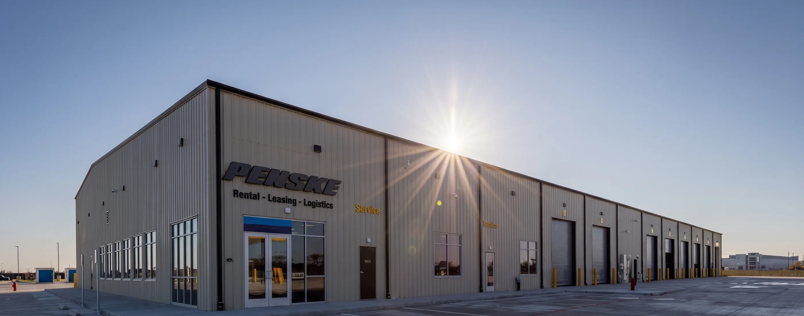 Entrance and office wing of the Penske Katy Service Center in low sun