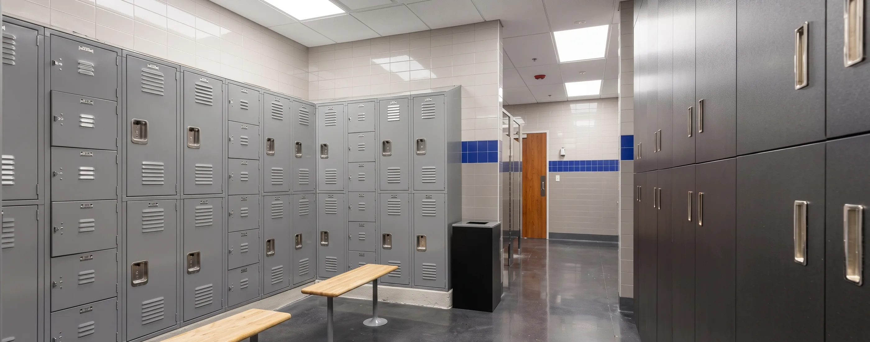 Locker room with gray lockers and a wood bench