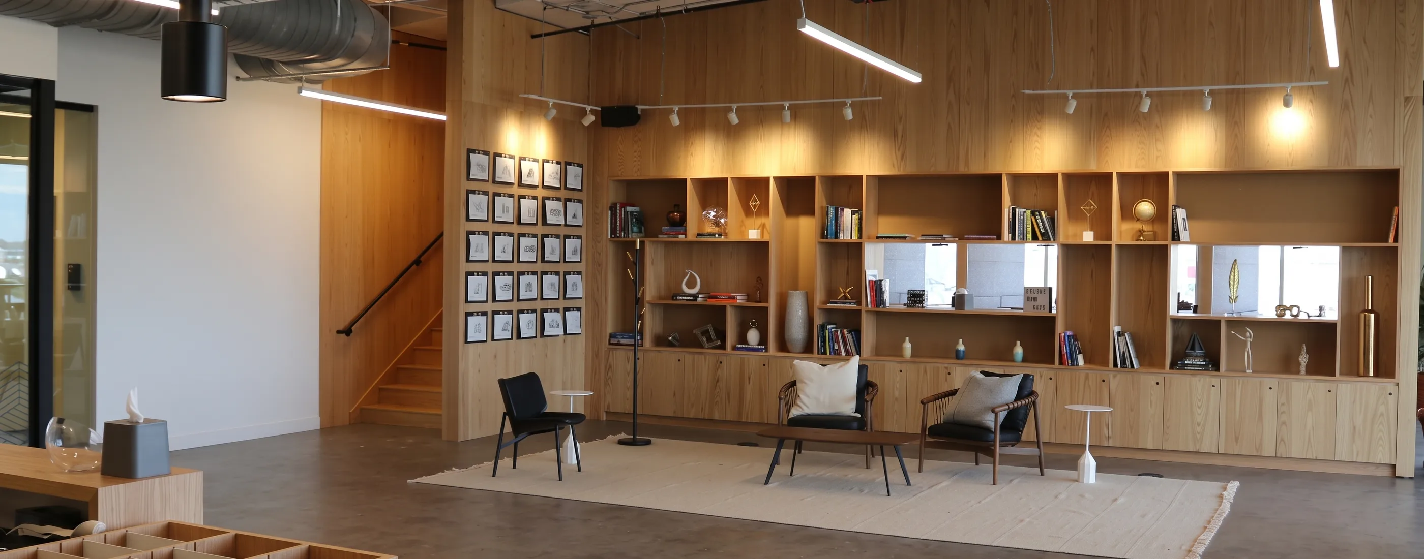 Lounge and library wall in white oak with a stair to the second floor of the office build-out